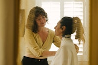 a woman is getting her hair done in a mirror